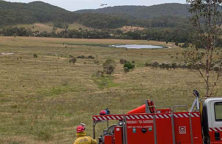 The crew of Pindimar/Tea Gardens Cat 7 watch a waterbomber refill. Photo: Mark Pryor.