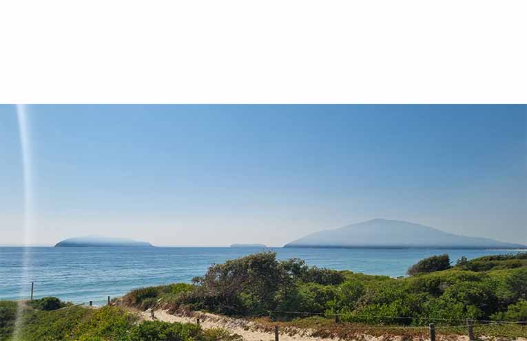 Smoke drifts over the coast, leaving a thick blanket above the water at Bennetts Beach. Photo: Thomas O’Keefe.