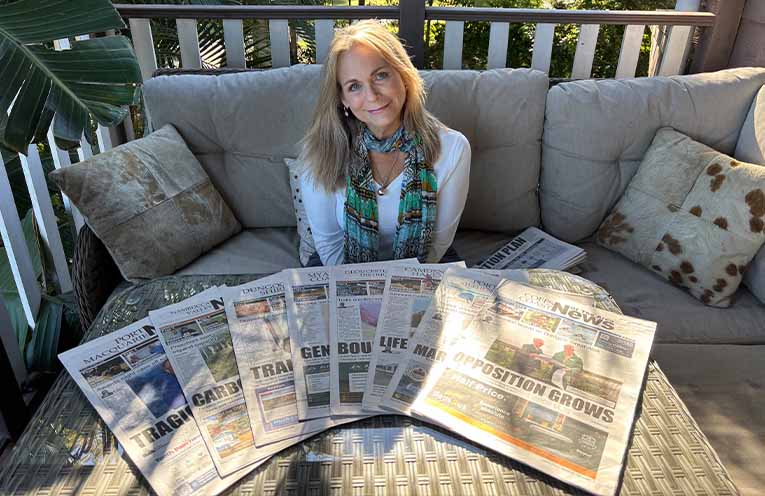 Eve with a few of her favourite things - eight different mastheads of News Of The Area. Photo: Angus Cheetham.