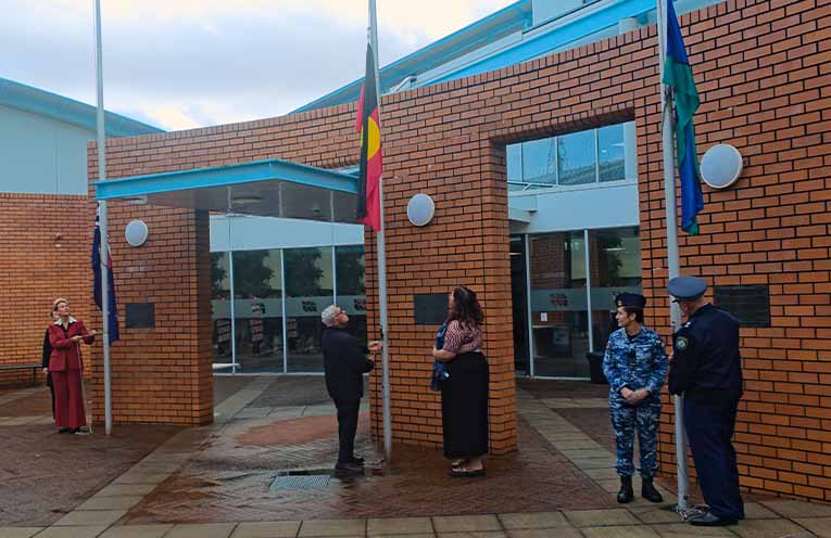 Mayor Leah Anderson, Uncle Neville Lilley, Maddie Lilley, Wing Commander Vicky Bezuidenhout and Superintendent Wayne Humprey hoist the flags to signal the start of NAIDOC Week 2026. Photo: Nico Lombardo.