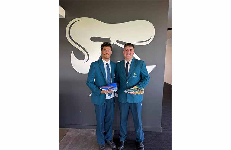 Students from Catherine McAuley Catholic College, Medowie present Newcastle Knights players with their hand-painted boots honouring Indigenous Round. Photos: CMCC Facebook.