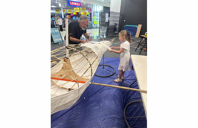 Phillip Relf getting some help to put the body together with a young Raymond Terrace local. Photo: Althea Guinsberg.