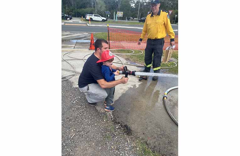 Lucas and his dad trying out the fire hose. Photo: Althea Guinsberg.