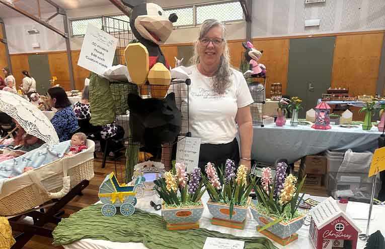 A stallholder with her handmade paper flowers and models at the Medowie Lions Art and Craft Fair. Photo: Althea Guinsberg.