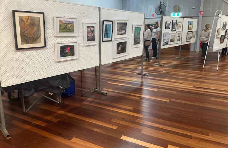 Visitors browse the artwork on display at the fair. Photo: Althea Guinsberg.
