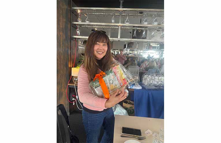 A delighted raffle winner celebrates her prize. Photo: Althea Guinsberg.